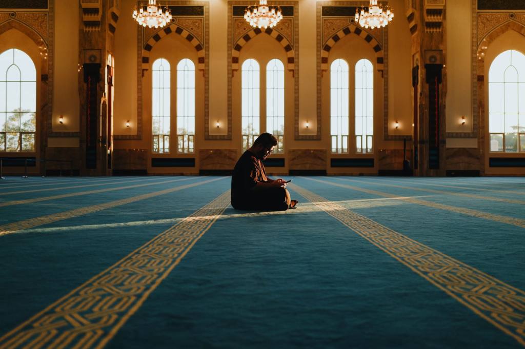A person meditating in the tranquil setting of Sendayan Mosque, Malaysia.