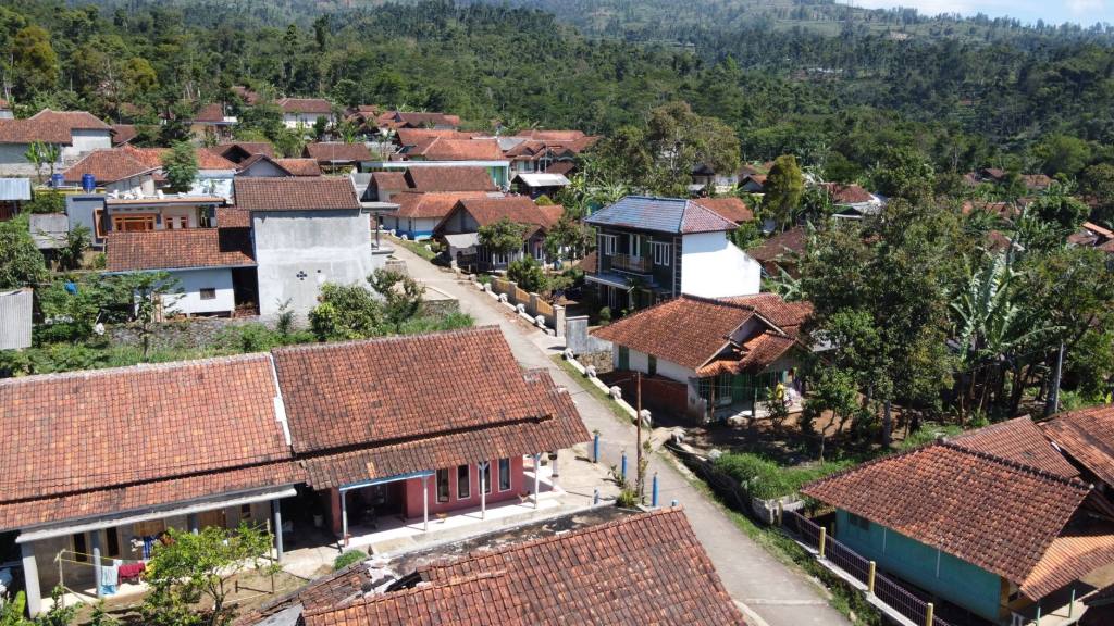 Drone shot of a traditional village with red-tiled roofs in Java, Indonesia, offering a scenic rural landscape.